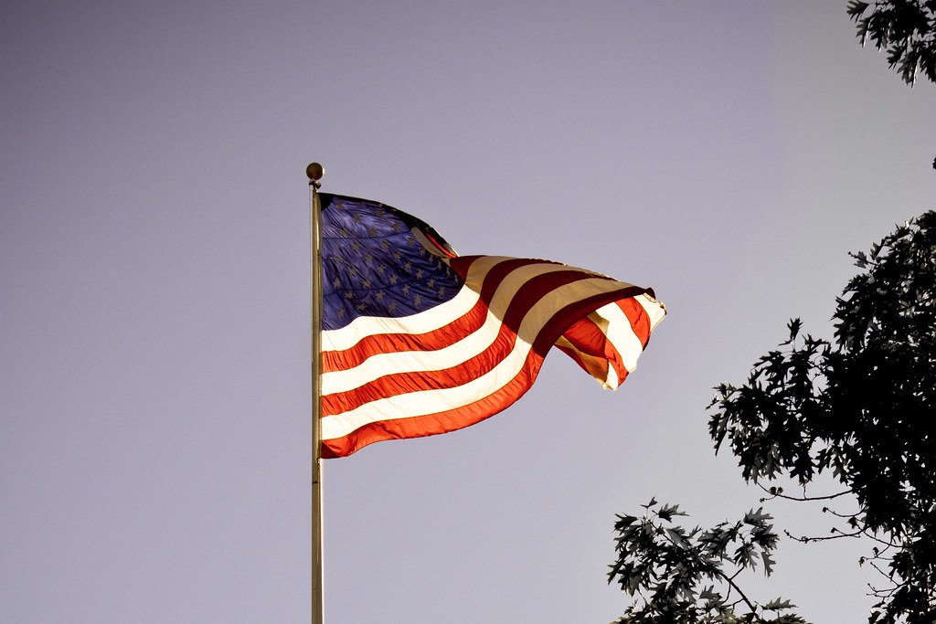 American flag waving against a blue sky